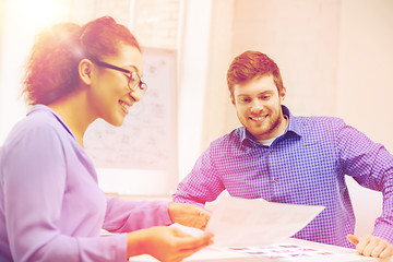 Image showing smiling team with paper at office