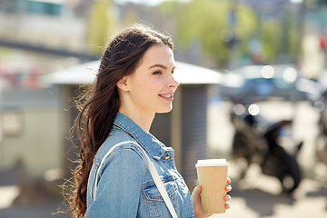 Image showing happy young woman drinking coffee on city street