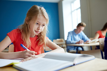 Image showing student girl with book writing school test