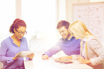 Image showing smiling team with table pc and papers working