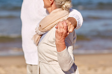 Image showing close up of happy senior couple hugging on beach