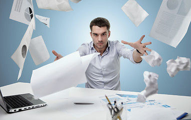 Image showing angry businessman throwing papers in office