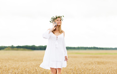 Image showing happy young woman calling on smartphone at country