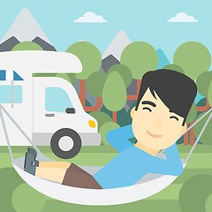 Image showing Man lying in hammock in front of motor home.