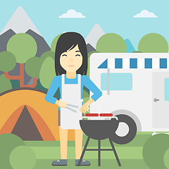 Image showing Woman having barbecue in front of camper van.