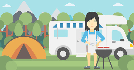 Image showing Woman having barbecue in front of camper van.