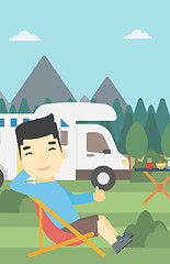 Image showing Man sitting in chair in front of camper van.
