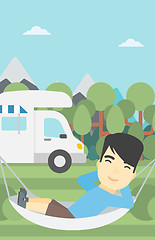 Image showing Man lying in hammock in front of motor home.