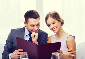 Image showing smiling couple with menu at restaurant