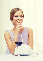 Image showing smiling woman with glass of whine waiting for date