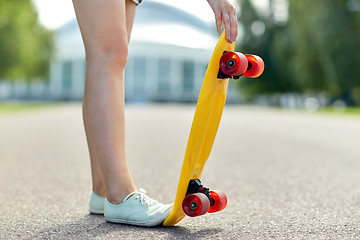 Image showing close up of female feet with short skateboard