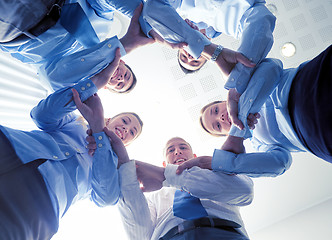 Image showing smiling group of businesspeople standing in circle