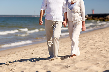 Image showing close up of senior couple walking on summer beach