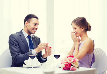 Image showing man proposing to his girlfriend at restaurant