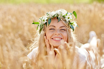 Image showing happy woman in wreath of flowers on cereal field