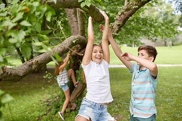 Image showing happy kids hanging on tree in summer park