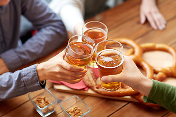 Image showing close up of hands clinking beer at bar or pub