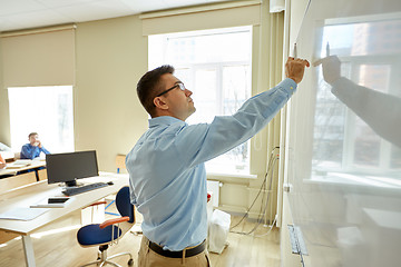 Image showing students and teacher writing on school white board