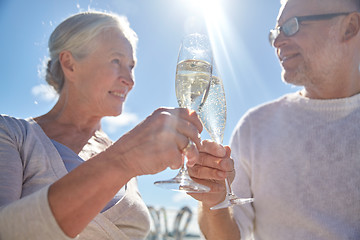 Image showing happy senior couple drinking champagne outdoors