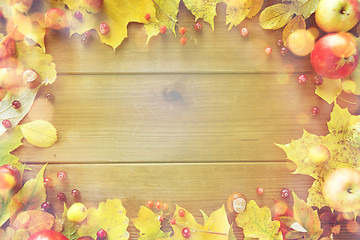 Image showing frame of autumn leaves, fruits and berries on wood