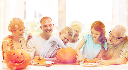 Image showing happy family sitting with pumpkins at home