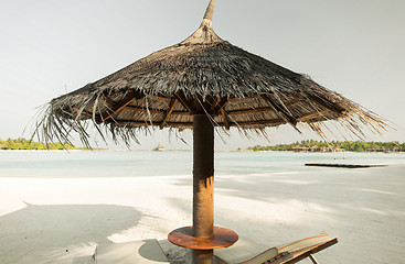 Image showing palapa and sunbeds by sea on maldives beach