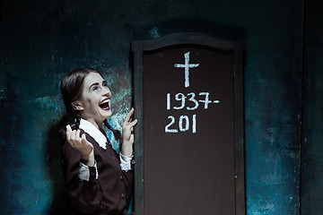 Image showing Portrait of a young smiling girl in school uniform as killer woman