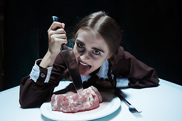 Image showing Bloody Halloween theme: crazy girl with a knife and meat