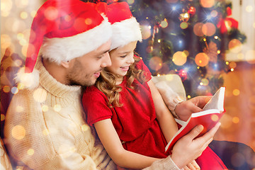 Image showing smiling father and daughter reading book