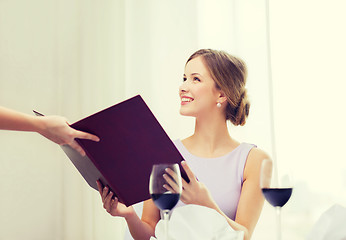 Image showing smiling woman recieving menu from waiter