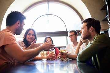 Image showing happy friends drinking beer at bar or pub