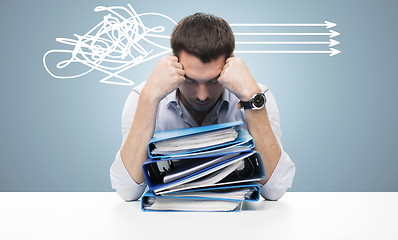 Image showing sad businessman with stack of folders at office