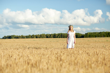 Image showing happy young woman in flower wreath on cereal field