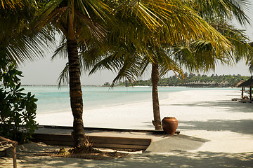 Image showing bungalow huts in sea water on exotic resort beach