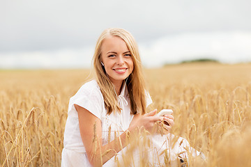 Image showing happy woman with smartphone and earphones