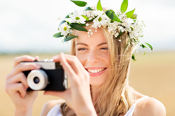 Image showing happy woman with film camera in wreath of flowers