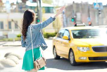 Image showing young woman or girl catching taxi on city street