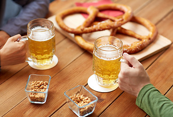 Image showing close up of hands with beer mugs at bar or pub