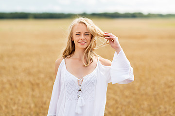 Image showing smiling young woman in white dress on cereal field