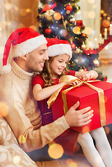 Image showing smiling father and daughter opening gift box