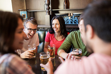 Image showing happy friends drinking beer at bar or pub