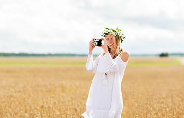 Image showing happy woman with film camera in wreath of flowers