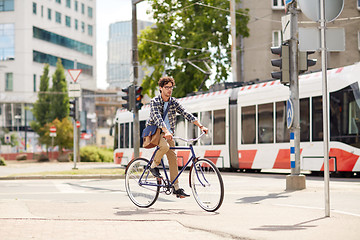 Image showing young hipster man with bag riding fixed gear bike