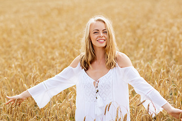 Image showing smiling young woman in white dress on cereal field