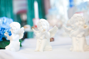 Image showing Three statues of angels on the table