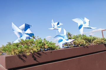 Image showing Toy windmills in a flowerpot with flowers