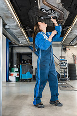 Image showing Female Mechanic Repairing Car On Hydraulic Lift