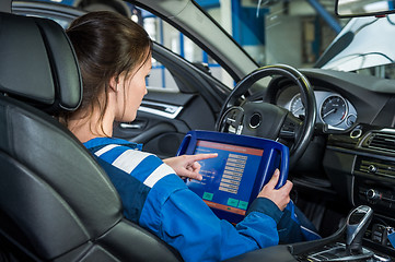 Image showing Mechanic Using Tablet Computer In Car At Garage