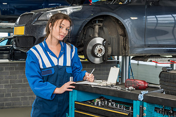 Image showing Confident Female Mechanic Writing Notes In Garage