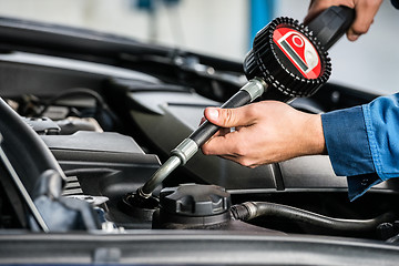 Image showing Mechanic Hands Filling Oil Into Car\'s Engine At Garage